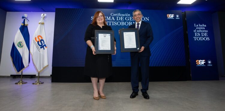 El certificado fue entregado a la superintendenta del Sistema Financiero, Evelyn Marisol Gracias, por el director general de AENOR Centroamérica, Arnulfo Pino.  Foto / Diario El Salvador.