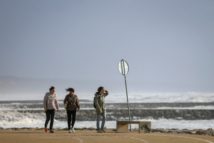 People walk along the promenade as Storm Marta whips up a rough sea in Costa da Caparica, Portugal, on February 7, 2026. The Iberian Peninsula was battered by Storm Marta today, bringing heavy rain and violent winds particularly to Andalusia, in southern Spain, and to Portugal, where a firefighter died during an operation in a river, ahead of an expected lull tomorrow. This latest harrowing episode comes after the devastating passage of Storm Leonardo mid-week in the region, which left two dead in Spain and another in Portugal, a country that has faced a succession of 'exceptionally violent' climate phenomena since January, according to its Prime Minister, Luis Montenegro. (Photo by PATRICIA DE MELO MOREIRA / AFP)