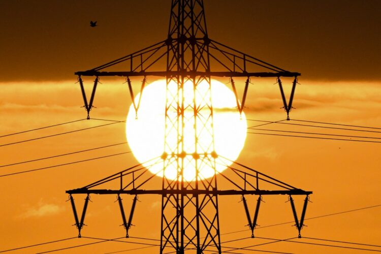 The sun rises behind a pylon and power lines in Frankfurt am Main, western Germany, on April 1, 2026. (Photo by Kirill KUDRYAVTSEV / AFP)