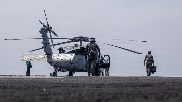 Marineros en tareas de mantenimiento a un helicóptero MH-60R Sea Hawk, en la cubierta de vuelo del portaaviones USS Abraham Lincoln. Foto: AFP